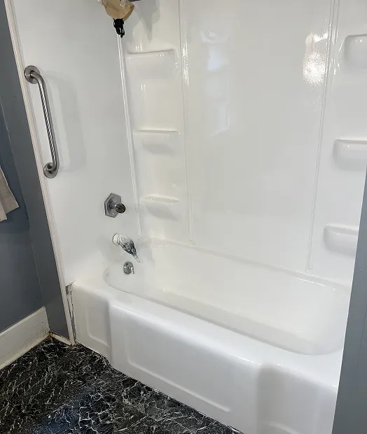 Professionally refinished white bathtub and shower surround with glossy finish in Queens