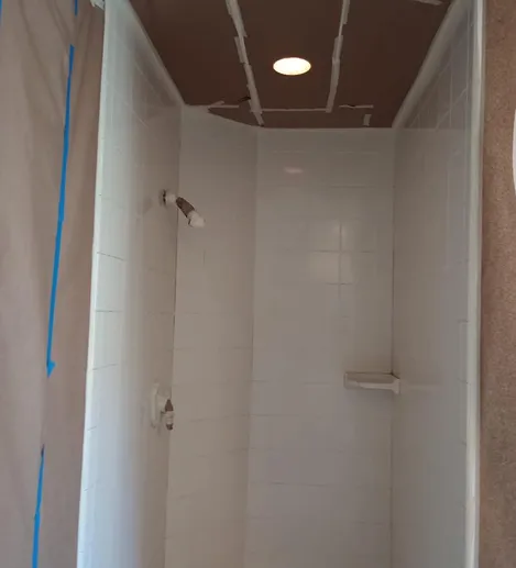 Professionally refinished white walk-in shower with glossy ceramic tile walls in Bronx