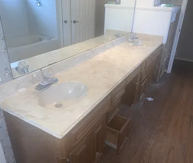 Bathroom vanity with double sinks and a large mirror reflecting a bathtub and doors.