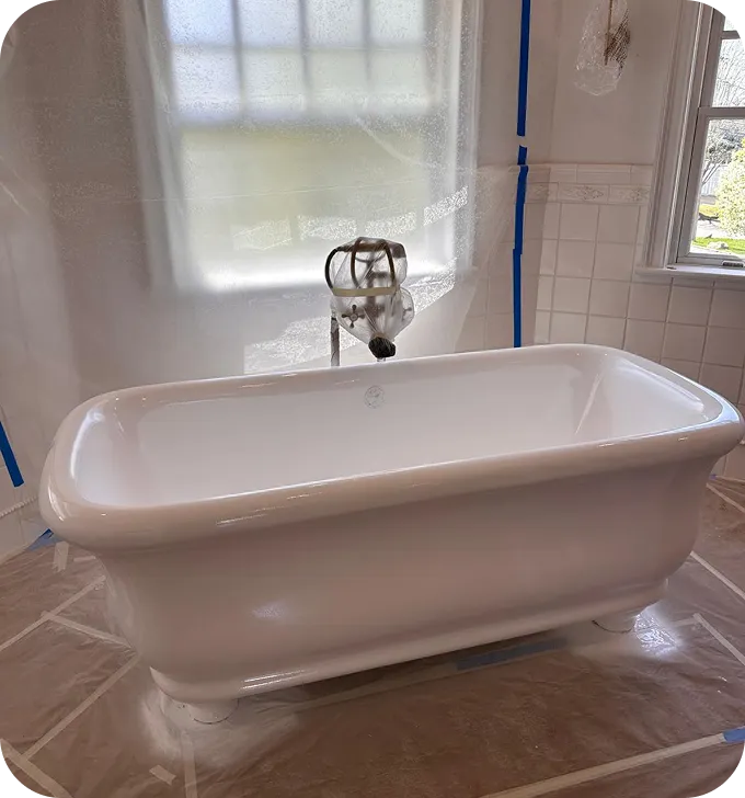 White clawfoot bathtub with protective plastic sheeting and blue tape in a bathroom under renovation.