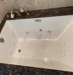 Professionally refinished white whirlpool bathtub with glossy finish in Brooklyn