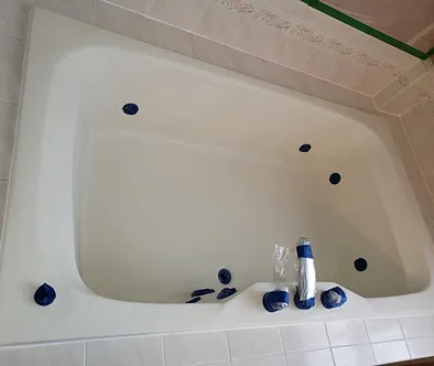White bathtub with blue jets and chrome faucet fixtures