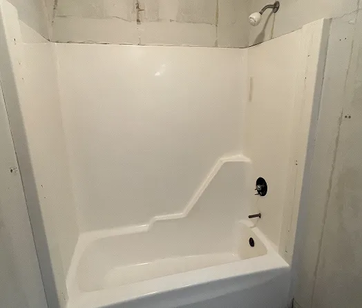 Freshly reglazed one-piece bathtub and shower enclosure with glossy finish in Bronx