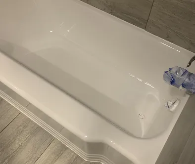 White bathtub with chrome faucet and blue plastic wrap