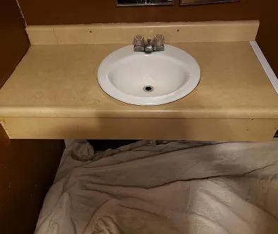 White sink and faucet on a beige countertop.