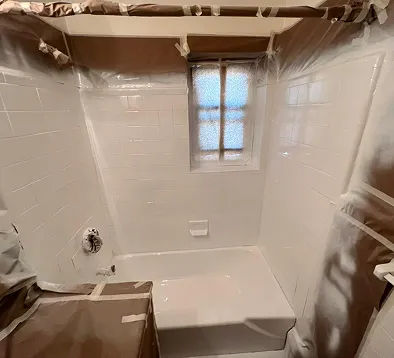 Professionally refinished white bathtub and shower tile surround in Bronx