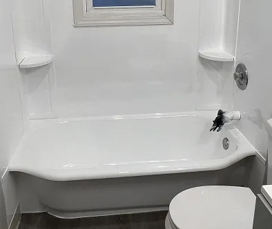 White bathtub with chrome fixtures and a small window above.