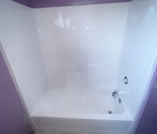 Professionally refinished white bathtub and shower surround with glossy finish in Bronx
