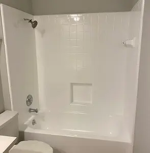 Professionally refinished white bathtub and shower surround with glossy finish in Brooklyn