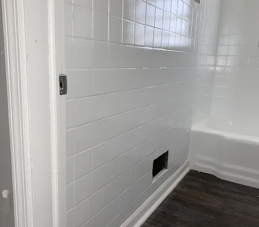 Professionally refinished white bathtub and ceramic tile surround in Queens