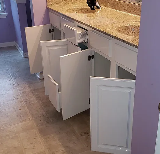 White bathroom vanity with all doors and drawers open, showing interior storage.