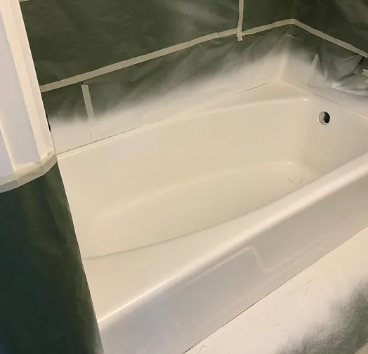 Bathtub being refinished with protective sheeting and tape.