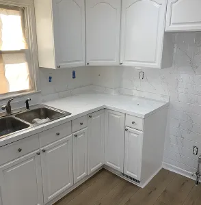 Refinished white kitchen cabinets with modern countertops in Bronx