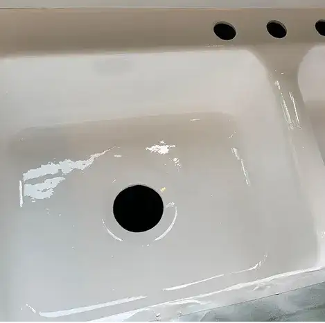 Professionally refinished white bathroom sink with glossy finish in Brooklyn