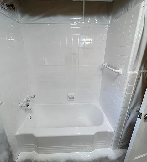 Freshly reglazed white bathtub with glossy ceramic tile surround in Bronx
