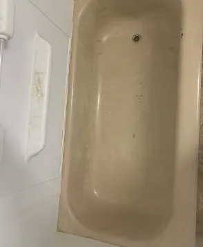 Bathtub before professional reglazing with worn surface in Queens