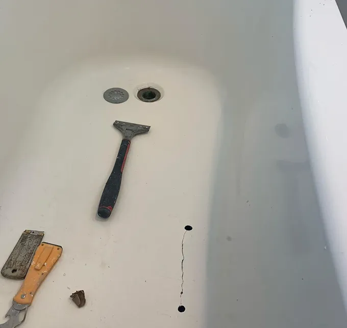 Scrapers and tools in a cracked bathtub