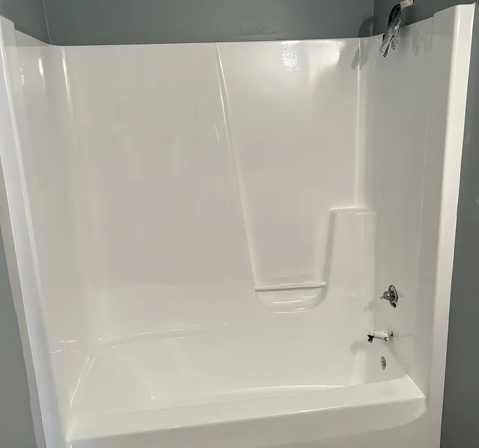 White bathtub and shower unit with chrome fixtures.