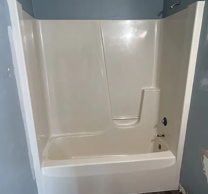 Cream bathtub and shower surround with chrome fixtures
