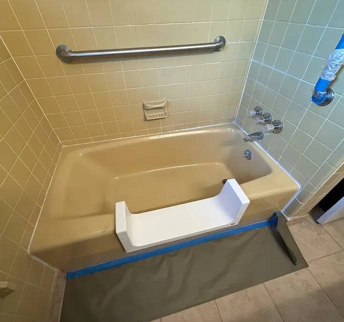 Bathtub with grab bar and a white tub step insert.